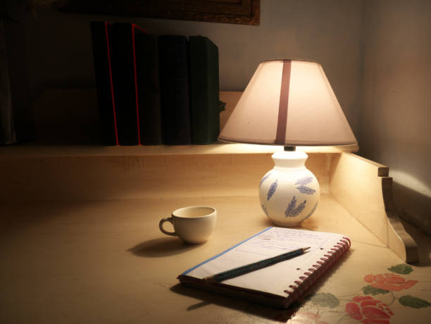 Journal and tea beside a warm lamp on an evening desk