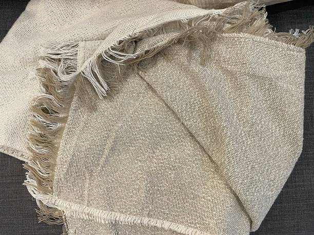 Natural linen and wool textiles layered on a bed